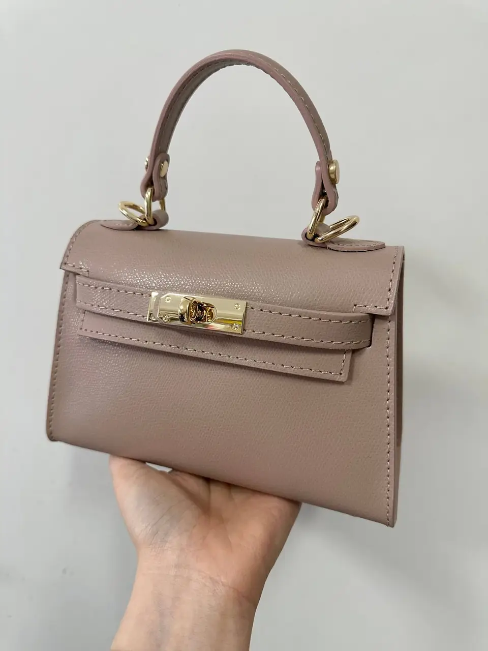 The taupe leather mini held in one hand